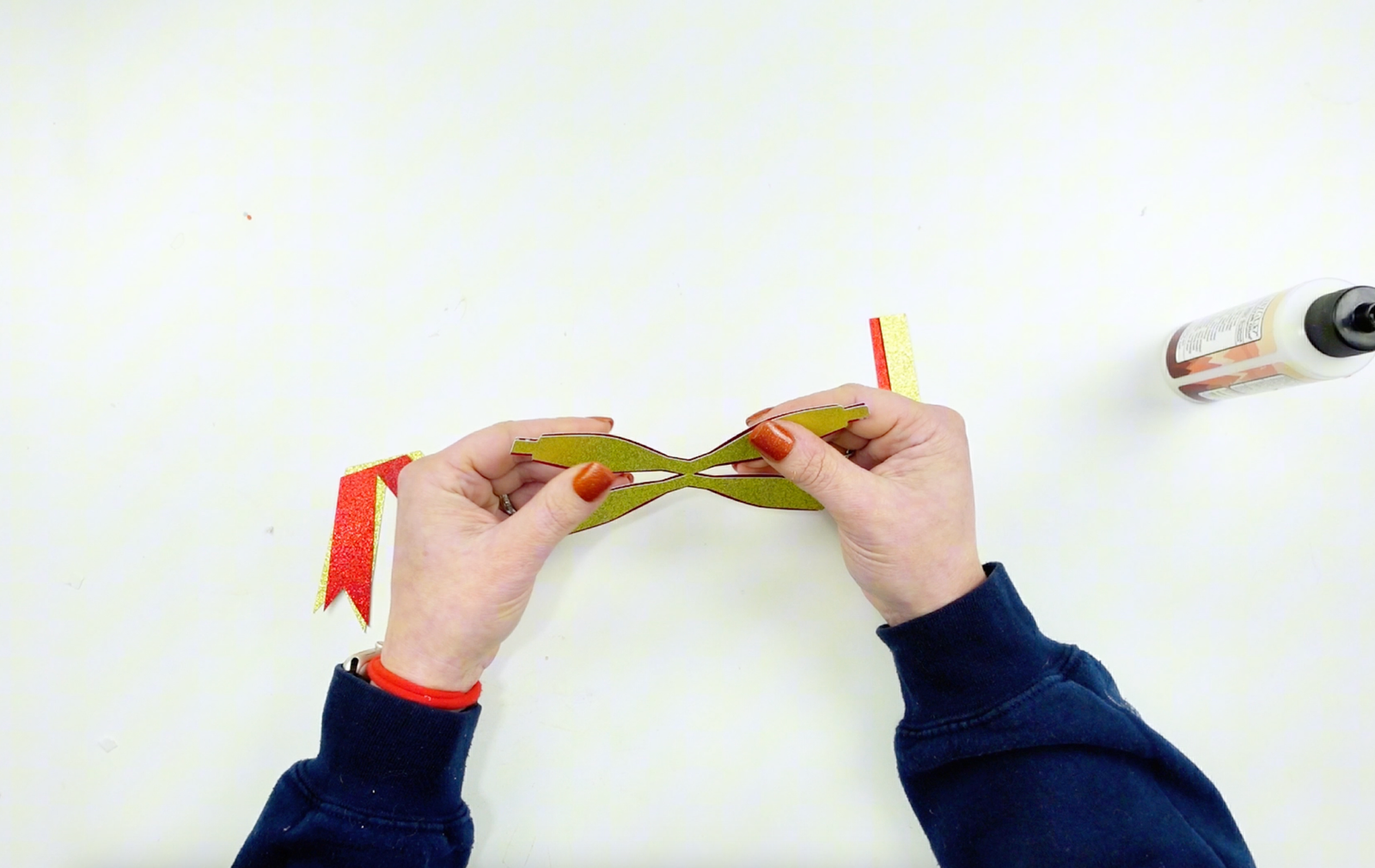 A DIY Christmas Bow made out of red and gold glitter cardstock. Free SVG File for Cricut and Silhouette. Layering two pieces of paper to create a beautful bow.